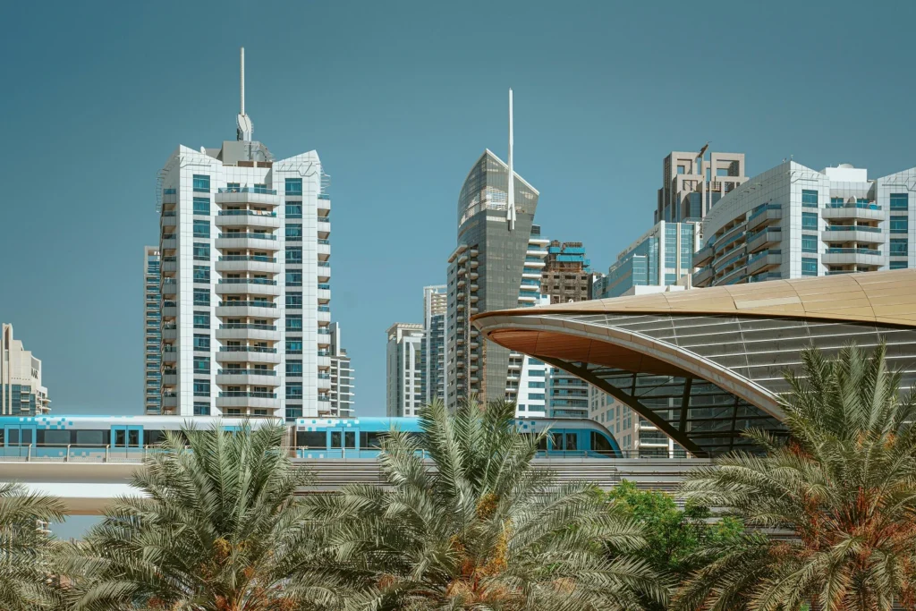 blue-train-in-a-railway-between-buildings-and-palm-trees